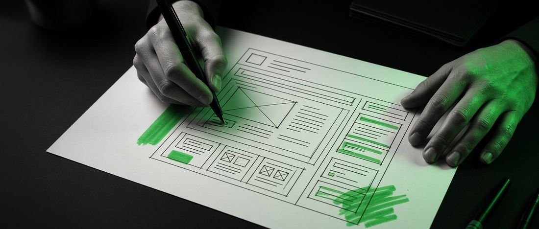 A web designer sketching a page layout on paper before building